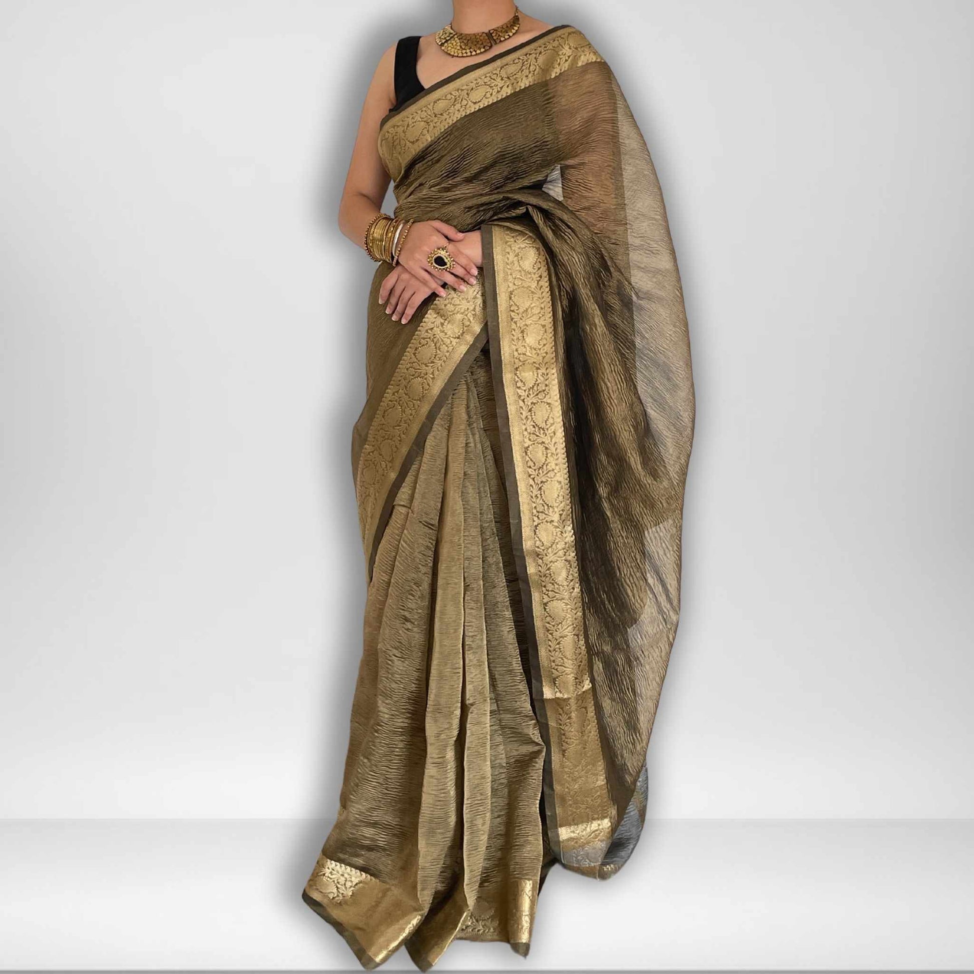 Dark grey crush tissue saree with Banarasi border and golden zari work, Work by Shobhangini. Sophisticated dark grey saree, ideal for evening events.