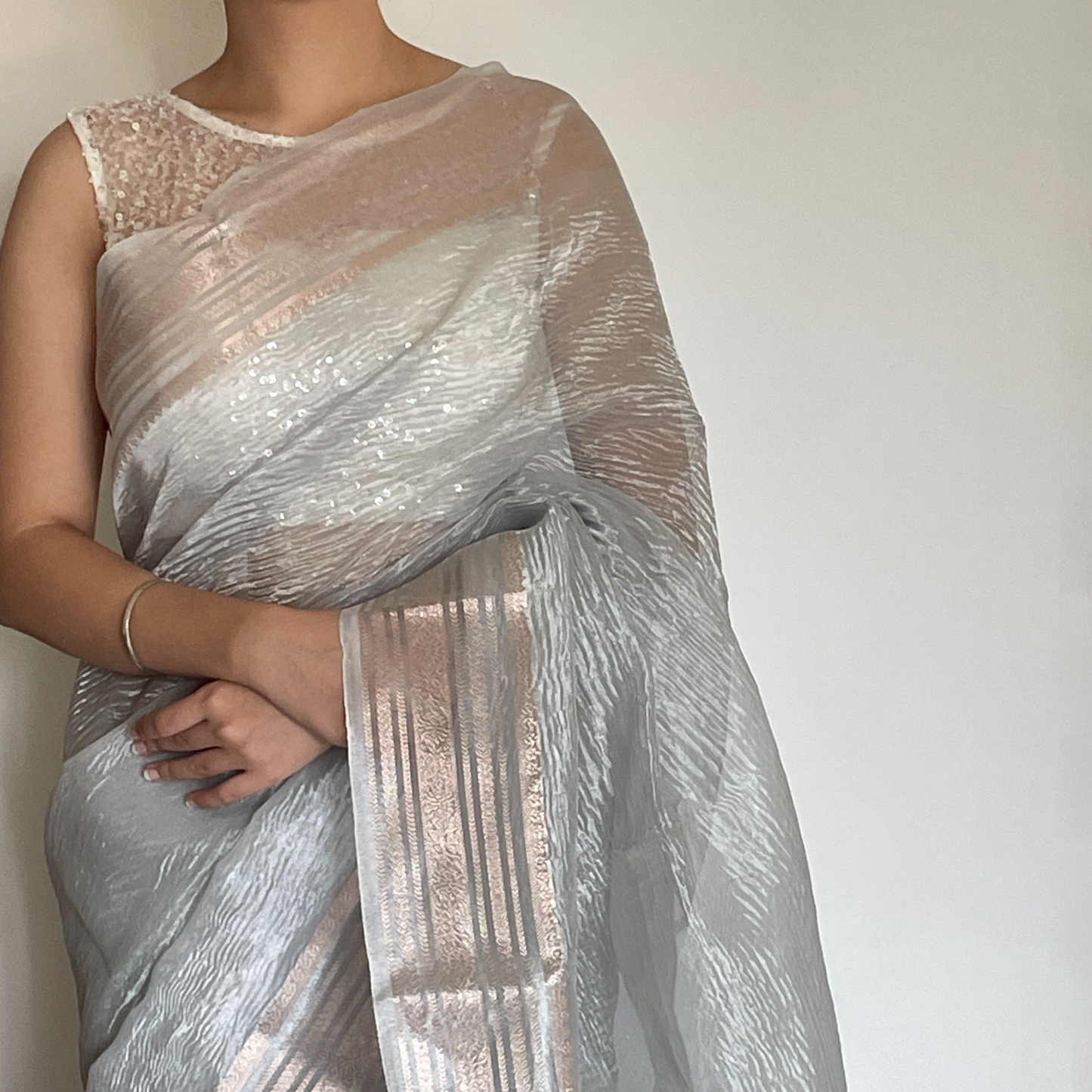 Silver metallic crush tissue saree with copper zari border, Work by Shobhangini. Modern silver saree, perfect for cocktail parties.