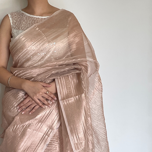 Rose gold metallic crush tissue saree with copper zari border, Work by Shobhangini. Trendy rose gold saree, ideal for festive celebrations.