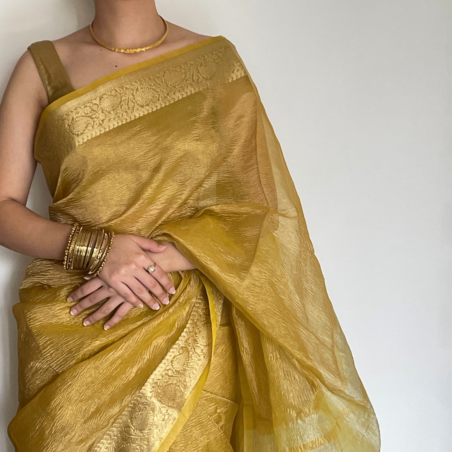 Yellow crush tissue saree with Banarasi border and golden zari work, Work by Shobhangini. Vibrant yellow saree, ideal for summer festivities.